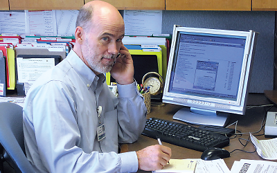 Photo: John Kern, M.D., sitting at desk with phone to ear.