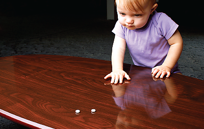 Photo: Toddler reaching across the table for pills