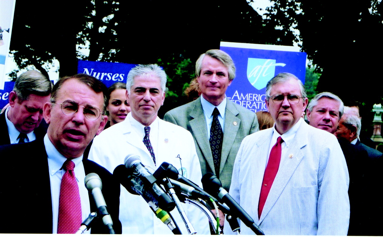 Rep. Greg Ganske (R-Iowa, at microphone) addresses a rally on the Patients’ Bill of Rights on Capitol Hill last month. He was joined by APA President Richard Harding, M.D. (center), Donald Palmisano, M.D., of the AMA (in white jacket), APA Medical Director Steven M. Mirin, M.D. (far right), and Rep. Marion Berry (D-Ark., behind Ganske). The rally took place before Charles Norwood (R-Ga., standing next to Harding) reached a controversial agreement with President George W. Bush that significantly altered the House bill.