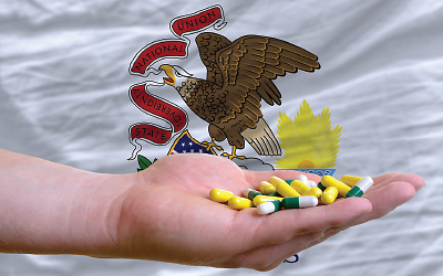 Hand of pills in front of Illinois state flag