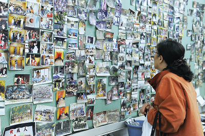 Photo: Woman looking at photos after Japan earthquake and tsunami