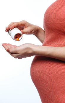 Photo: Pregnant woman taking pills