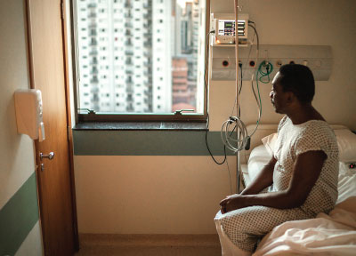 Photo: patient looking out of the window in a hospital bed