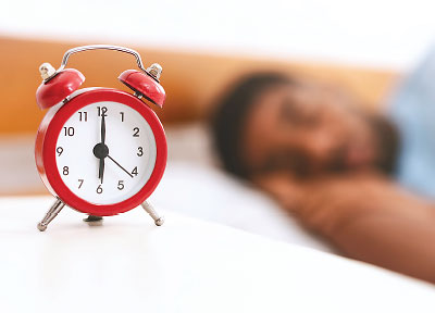 Photo: alarm clock with bearded man sleeping in the background