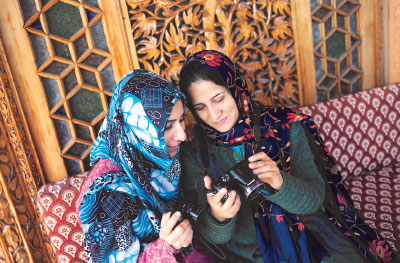 Photo: Kashmiri ladies talking and looking at photocameras