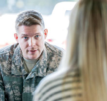 Photo: military in fatigue talking with a lady