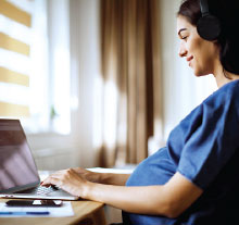 Photo: pregnant woman typing on a laptop