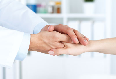 Photo: doctor gently holding the hand of a patient