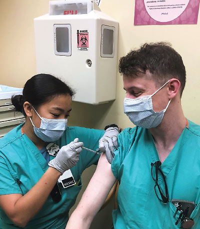 Photo: Capt. Kevin Brown, a physician at Tripler Army Medical Center in Honolulu, is vaccinated for COVID-19 days after the first vaccination was approved.