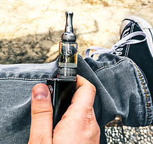 Photo: young person holding an e-cigarette in its hands