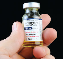 Photo: hand holding a vial of Methotrexate