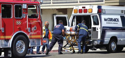 Photo: EMS pushing a stretcher into an ambulance
