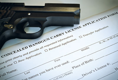 Photo: Gun over a conceiled permit form