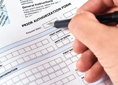 Hand filling a prior authorization form