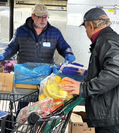 Two volunteers with Jewish Family Service in Denver stock up the organization’s food pantry.