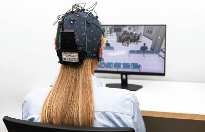 Users of the PRISM device watch a monitor while their brain waves are recorded. Over repeat training sessions, users learn how to get people to sit down in a noisy hospital waiting room by relaxing their thoughts.