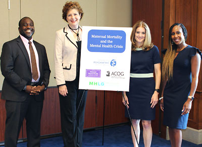 Photo: Denis Godwin Antoine II, M.D., Adrienne Griffin, M.P.P., Nancy Byatt, D.O., M.S., M.B.A., and Veronica Gillispie-Bell, M.D., M.A.S, stand on either side of a poster board that reads: Maternal Mortality and the Mental Health Crisis.