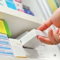 Hand picking a box of medications