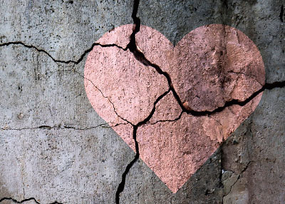 pink heart painted on a cracked cement wall