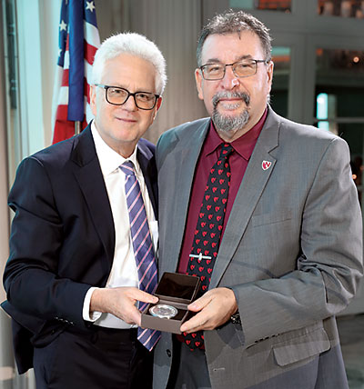 Karoly Mirnics, M.D., Ph.D. (right), accepts the 2023 Pardes Humanitarian Prize on behalf of Special Olympics International from BBRF President Jeffrey Borenstein, M.D.
